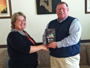 Carla Livingston receives a free kindle from Newberry Electric Cooperative CEO Keith Avery